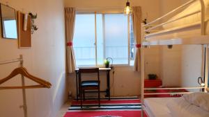 a room with a couch, chair, and a window at Zabutton Hostel and Coffee in Tokyo