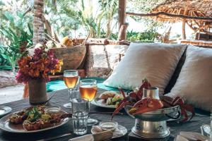a table with plates of food and drinks on it at Che Shale in Mambrui