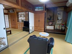 ein Wohnzimmer mit einem Stuhl und einem Tisch in der Unterkunft てぃだかんかん Tida-kan-kan -SEVEN HOTELS & Resorts- in Motobu