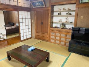 ein Wohnzimmer mit Couchtisch und Fernseher in der Unterkunft てぃだかんかん Tida-kan-kan -SEVEN HOTELS & Resorts- in Motobu + 41 Fotos