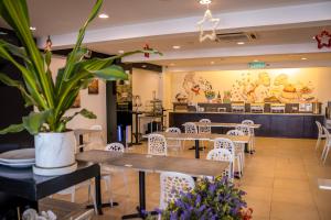 Prescott Hotel Bukit Bintang في كوالالمبور: مطعم به طاولات وكراسي ومصنع الفخار