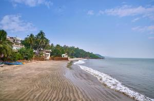a sandy beach with houses and the ocean at The Hawaii Comforts Panjim in Panaji