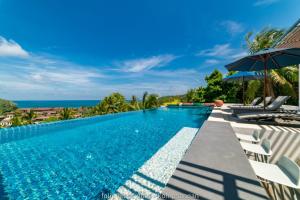 a swimming pool with a view of the ocean at Folie Bleue Villa in Mae Haad