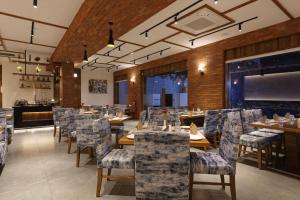 a restaurant with tables and chairs and a large screen at HOTEL FLOURISH INTERNATIONAL in Ahmedabad