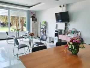 a living room with a table and chairs and a tv at Orchid Surin in Surin