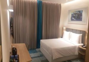 um quarto de hotel com uma cama e uma mesa em Holiday Inn Express & Suites Bengaluru Old Madras Road, an IHG Hotel em Bangalore