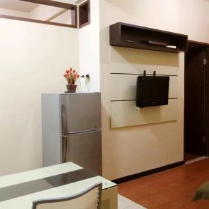 a kitchen with a refrigerator, microwave and a table at Apartemen The Suites Kayla in Bandung