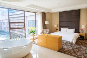 ein Hotelzimmer mit einem Bett und einer Badewanne in der Unterkunft Holiday Inn Foshan Nanhai Central, an IHG Hotel in Foshan
