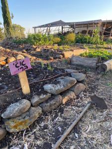 un jardín con rocas y una señal en él en suite truck- Natura Eco farm, en Natur