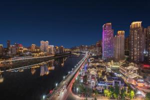 a city at night with a river and buildings at Boutique of Meditation with Cuisine & Night View, Exit 2 Liujiatai Station Line 9 in Chongqing