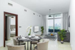 a white living room with a table and chairs at LUX - Opulent Island Suite 5 in Dubai