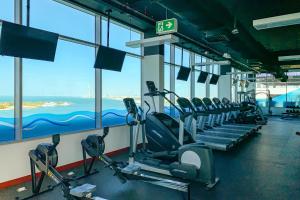 un gimnasio con filas de cintas de correr y una gran ventana en LUX - Opulent Island Suite 5, en Dubái