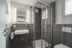 a bathroom with a glass shower and a sink at Hotel Bernerhof in Interlaken +83 photos