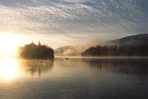 un lago nebuloso con un barco en el agua en Windhaghof en Kramsach