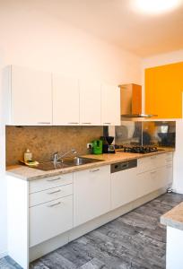 eine Küche mit weißen Schränken und einem Waschbecken in der Unterkunft Highlight Suite Donaustadt in Wien