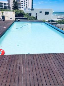 a large swimming pool on top of a building at Infinity Self Catering Beachfront Apartment 302 in Cape Town