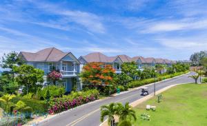 eine Straße mit Häusern und einem Auto, das eine Straße hinunter fährt in der Unterkunft Sea Links Villa Resort & Golf in Mui Ne