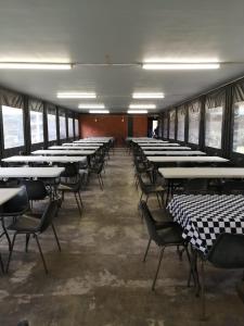 eine Reihe von Tischen und Stühlen in einem Zimmer in der Unterkunft Dirkie Uys Backpackers in Durban