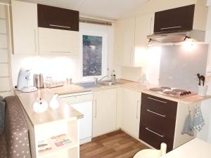 a small kitchen with white cabinets and a sink at détente au cœur de la ferme in Lacroix-sur-Meuse +7 photos