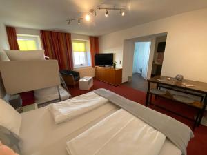 ヴェルグルにあるBed & Rooms, Wörglのベッド1台付きの部屋、リビングルーム(テレビ付)