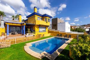 żółty dom z basenem na dziedzińcu w obiekcie Milestone House w mieście Rincón de la Victoria