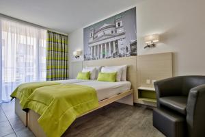 ein Hotelzimmer mit einem Bett und einem Stuhl in der Unterkunft Hotel Santana in St Paul's Bay