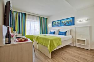 a hotel room with a bed and a television at Hotel Santana in St. Paul's Bay