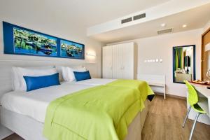a bedroom with a large bed and a desk at Hotel Santana in St. Paul's Bay