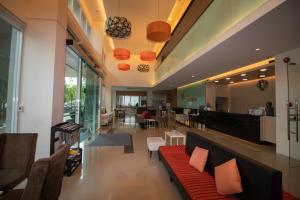 a lobby with a red couch and a restaurant at Phavina Grand Boutique in Rayong
