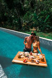 a man and woman standing next to a table in a pool at Munjoh Ocean Resort - Private Beachfront Luxury Retreat in Havelock in Havelock Island