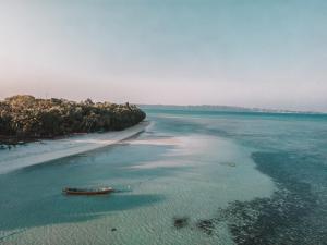 an aerial view of a beach with a boat in the water at Munjoh Ocean Resort - Private Beachfront Luxury Retreat in Havelock in Havelock Island