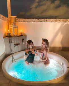 羅馬的住宿－馬爾科安東尼奧豪華套房旅館，两个女孩坐在浴缸里