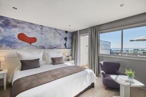 a hotel room with a large bed and a painting on the wall at Hotel Joan Miró Museum in Palma de Mallorca