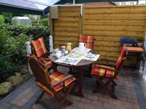 une table et quatre chaises assises sur une terrasse dans l'établissement Bastan - Haus Katharina, à Emden