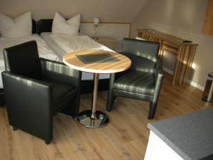 a table and two chairs in a room with a bed at Bastan - Haus Katharina in Emden