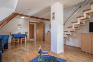 een woonkamer met een blauwe bank en een trap bij Ferienwohnung Nr 1 in Deggenhausertal