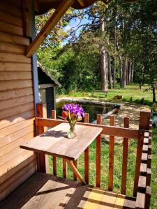 a wooden picnic table with a vase of flowers on it at La Roulotte de Negra in Montesquieu-Lauragais