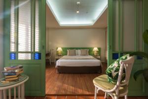 a bedroom with a bed and a chair and a table at Kantary Bay Hotel Phuket in Panwa Beach