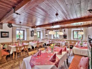 巴特法伊爾恩巴赫的住宿－Landgasthof Aumanwirt，餐厅设有白色的桌椅和木制天花板。