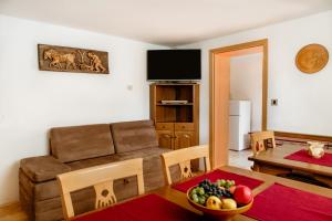 a living room with a couch and a table with a bowl of fruit at Apartments Kristan in Bled