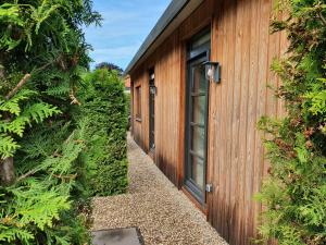 un bâtiment en bois avec une porte et quelques plantes dans l'établissement B&B Mooi Zelhem, à Zelhem