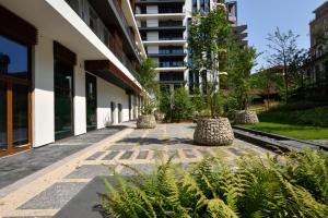 une cour dans un bâtiment avec des arbres et des plantes dans l'établissement Milano Verticale | UNA Esperienze, à Milan