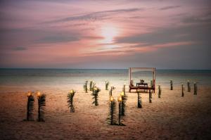 a beach with a table and candles in the sand at Munjoh Ocean Resort - Private Beachfront Luxury Retreat in Havelock in Havelock Island