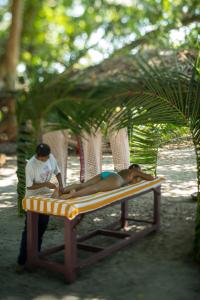 a woman laying on a bed on a beach at Munjoh Ocean Resort - Private Beachfront Luxury Retreat in Havelock in Havelock Island
