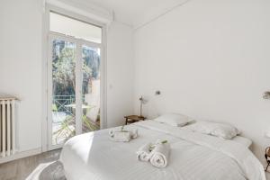 - une chambre blanche avec un grand lit et des serviettes dans l'établissement IMMOGROOM - EXCLUSIVE - Terrace - Amazing quiet place - Wifi, à Cannes