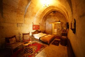 a bedroom with a bed and a couch in a room at Ürgüp Inn Cave Hotel in Ürgüp