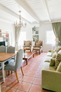 Knorhoek Country Guesthouse في ستيلينبوش: غرفة معيشة مع أريكة وطاولة وكراسي