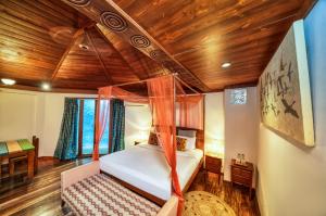 a bedroom with a bed and a wooden ceiling at Munjoh Ocean Resort - Private Beachfront Luxury Retreat in Havelock in Havelock Island