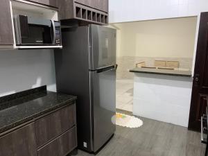 a kitchen with a stainless steel refrigerator in a kitchen at Linda casa de Veraneio in Guarujá