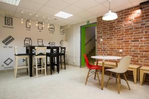 a room with tables and chairs and a brick wall at Moon Hostel Gdańsk in Gdańsk